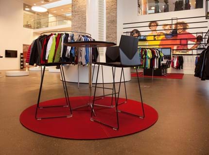 Rødt, rundt filtttæppe i showroom